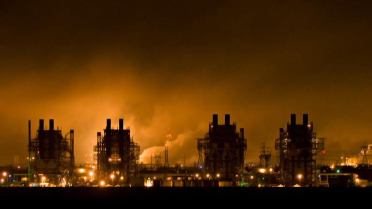 Nighttime photo of power generation plant buildings with fog and backlighting.