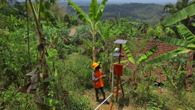 Officer checking the condition of the solar panel, early warning system, in anticipation of landslides