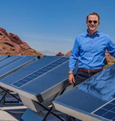 Cody Friesen standing by an installed row of installed solar-powered water harvesters