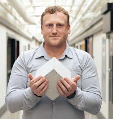 “Roman concrete to me is fascinating: It’s still standing after all this time and constantly repairing,” Admir Masic says, pictured here holding a Roman-inspired, self-healing concrete cube. 